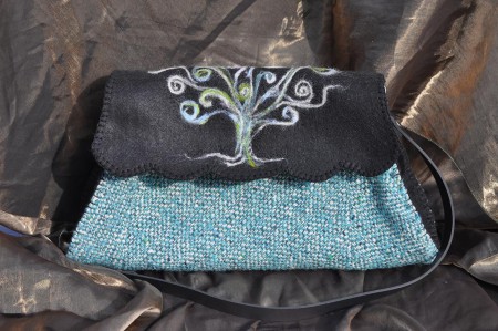 Borsa in feltro e stoffa. La stoffa è ricavata dal riciclo di una vecchia gonna, il decoro esterno è realizzato a punzone con fili di lana cardata.