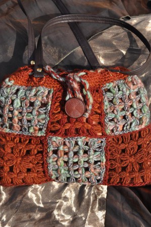 Borsa marrone e verde, realizzata in lana a telaio e completamente foderata.