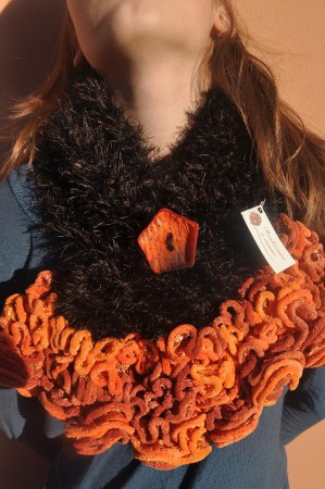 Sciarpa nera e arancio in lana, realizzata ai ferri.