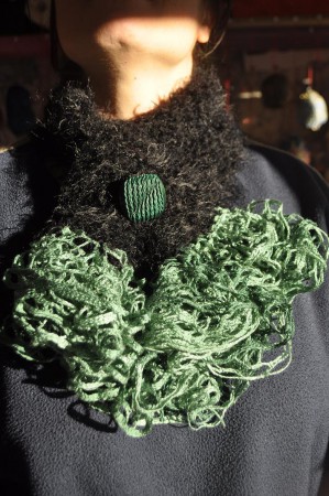Sciarpa in lana nera e verde, realizzata ai ferri.