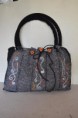 Borsa grigia, realizzata interamente a mano con lana cotta e feltro. Decori inseriti a punzone.