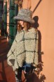 Poncho verde in lana, realizzato a telaio.